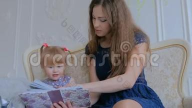 年轻的母亲和她的小女儿正在看照片
