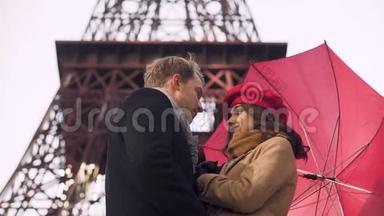 美丽的年轻情侣在雨伞下温柔接吻，在巴黎浪漫约会