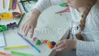 快乐的小女孩把五颜六色的塑料<strong>放在</strong>一个容器里，<strong>桌面上</strong>是数字和彩色铅笔，