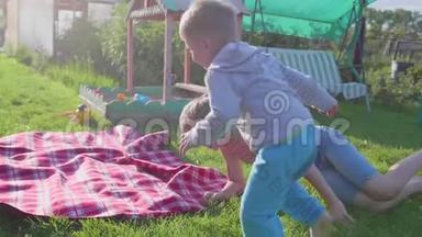 两个孩子在<strong>炎热的夏天</strong>在草坪上玩耍。 孩子们笑着，他们跑着落在草坪上。 户外娱乐