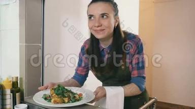 一个女服务员从餐厅的厨房拿着一盘白色盘子