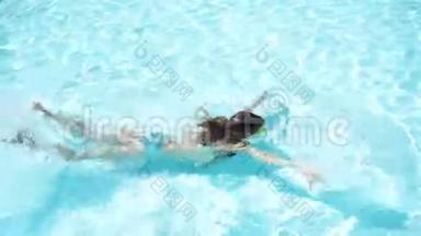 可爱快乐的小女孩喜欢在游泳池里游泳。 家庭暑假，孩子在游泳池放松。