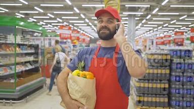 一个英俊的送货员，带着购物袋，在超市里用智能手机<strong>点餐</strong>