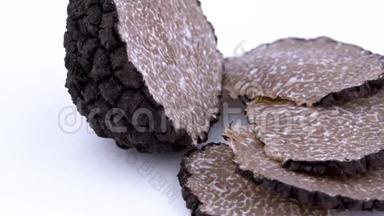 大片的黑松露切片和一半的松露蘑菇慢慢地旋转在转盘上。 孤立存在