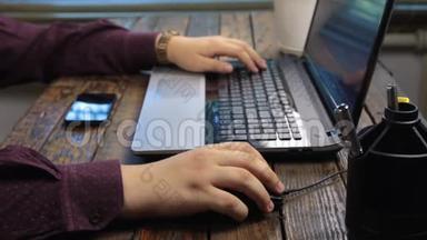 人在笔记本电脑上工作，使用鼠标和笔记本键盘。