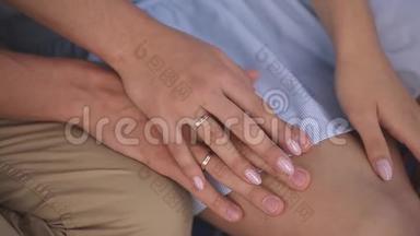 最近结婚的家伙牵着他年轻妻子的手。 结婚戒指和手掌紧闭。