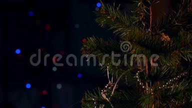 一位女士在圣诞树叶子上挂着圣诞装饰，上面有闪闪发光的LED