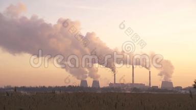 工厂在日落时从管道中排<strong>放</strong>烟雾，污染物进入大气。