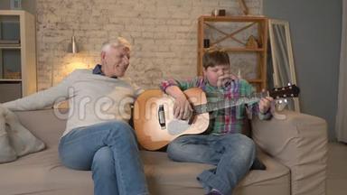 孙子为爷爷<strong>弹吉他</strong>，音乐.. 一位老人和一位年轻的胖子坐在一起<strong>弹吉他</strong>
