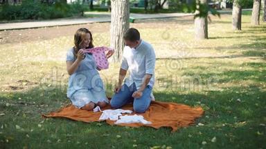 怀孕夫妇看着婴儿衣服出门