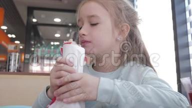 漂亮的女孩在路边的咖啡馆里吃热狗。 快餐在汽车旅行的概念。