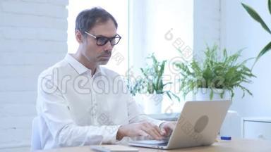 失去，沮丧的中年男人在手提电脑上工作