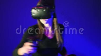 女人玩3D虚拟现实游戏。 在射击VR游戏中使用控制器射击。 穿着蓝色VR耳机的女孩