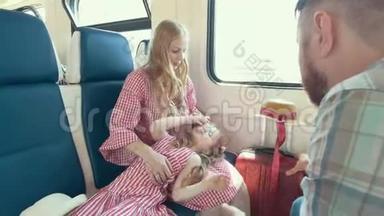 年轻的白种人<strong>一家人一起</strong>旅行-母亲、父亲和小女儿在靠近窗户的火车上交谈
