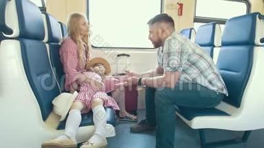 快乐的年轻家庭一起旅行-在火车上交谈，<strong>看着窗外</strong>