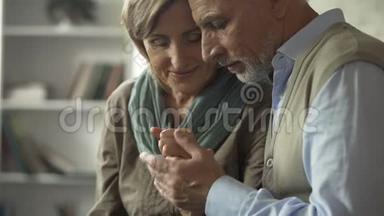 <strong>幸福</strong>的老夫妻坐在一起，男人亲吻女人的手，成功的<strong>婚姻</strong>