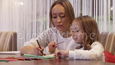 一位迷人的年轻女子妈妈和她<strong>可爱</strong>的小女儿<strong>画画</strong>
