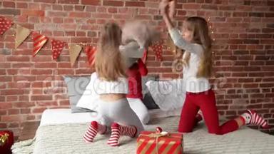 穿着睡衣的三胞姐妹用枕头安排了<strong>打斗</strong>。 卧室装饰着圣诞花环和圣诞节