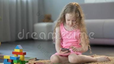 小女孩忽视玩具，在手机应用程序中玩游戏，沉迷于智能手机