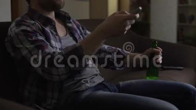 男子膝盖上拿着一瓶啤酒，用遥控器切换电视频道