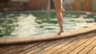 暑假的年轻女子跳进清澈的<strong>蓝色</strong>游泳池里，在炎热的阳光明媚的日子里用溅满水花和