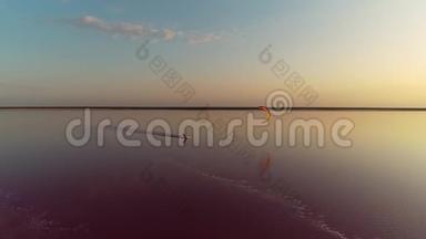 夕阳落在一个粉红色的湖上，一个放风筝的人沿着一个平静的湖狂奔