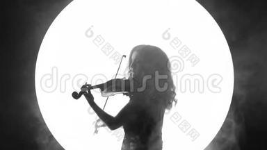 一个美丽的女孩在烟雾中的白色圆圈背景上拉小提琴的黑白视频片段。