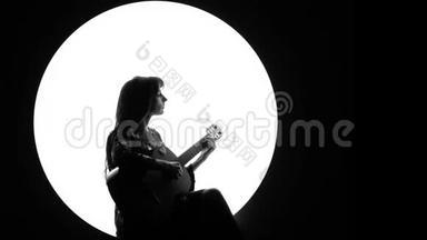 一个黑色和白色的<strong>视频</strong>片段，一个美丽的女孩在古典吉他上演奏，在<strong>烟雾</strong>中的白色圆圈。