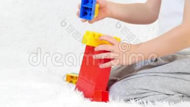 幼儿双手特写，在彩色积木中玩耍，坐在白色背景上.. 孩子和玩具。 运动摄影机