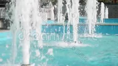 小镇中心的喷泉高高的溪流。 游泳池的蓝色水。 晴天，市中心天气温暖