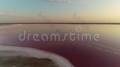 日落时分，一名男子在一个美丽的粉红色湖泊中进行风筝冲浪，全景