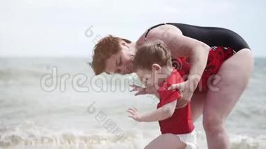 快乐的孩子和奶奶在海边玩耍，小男孩开心地笑着，笑着，在海浪上跳跃