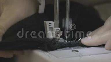 缝纫机针的特写迅速上下移动.. 黑色织物