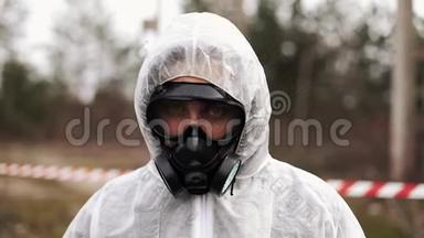 一个穿着生物危害防护服戴着防毒面具的男人径直走向镜头