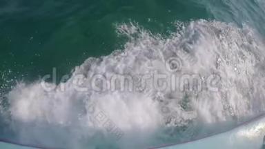 强大的海浪从快速移动的船上抽出，一股巨大的深蓝水和白色泡沫上升