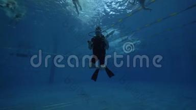潜水者戴潜水面罩和潜水设备在水下游泳池游泳