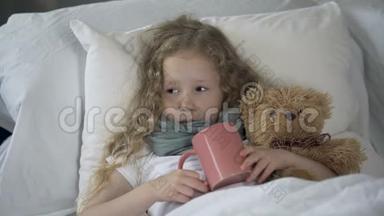 生病的孩子躺在床上，杯子里放着<strong>热饮料</strong>，生病的女孩因喉咙疼痛而哭泣