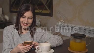 一个女人在一张桌子上的咖啡馆里喝着茶，翻阅着一盘社交网络