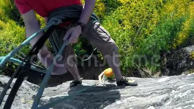 攀岩者在攀登悬崖4k时调整攀岩绳