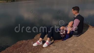 女孩躺在河岸上一个男人的脚上。