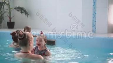 快乐的中年妈妈和<strong>可爱</strong>的<strong>可爱宝宝</strong>在游泳池游泳.. 微笑的妈妈和小孩，新生的女孩