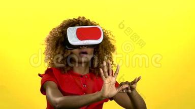 在虚拟现实眼镜中的穆拉托正在<strong>观看</strong>一段有趣的<strong>视频</strong>。 黄色背景。 慢动作