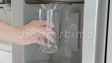 把冰箱门上的冰块倒入玻璃杯