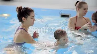 快乐的中年<strong>妈妈</strong>和可爱的可爱<strong>宝宝</strong>在游泳池游泳.. 微笑的<strong>妈妈</strong>和小孩，新生的女孩