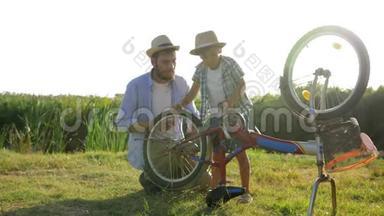 家庭休闲，孩子和父亲在乡村的背景下在背光下修理自行车