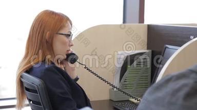 红头发的女信贷经理的<strong>画像</strong>，她通过电话与<strong>客户</strong>交谈。