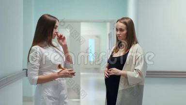 一位女医生和一位年轻的孕妇站在移植中心的走廊里，医生问