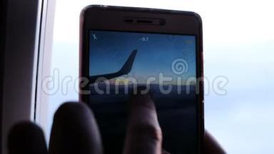 乘客在智能手机上的照片，从<strong>飞机</strong>窗口，机翼和天空与<strong>云彩</strong>在日落，特写