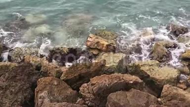 强烈的波浪溅在石头上。 海浪撞击岩石海岸。 海洋溅到岩石上