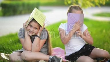 两个有趣的女孩在玩书。 他们在微笑，有很多乐趣。 <strong>天气晴朗</strong>。